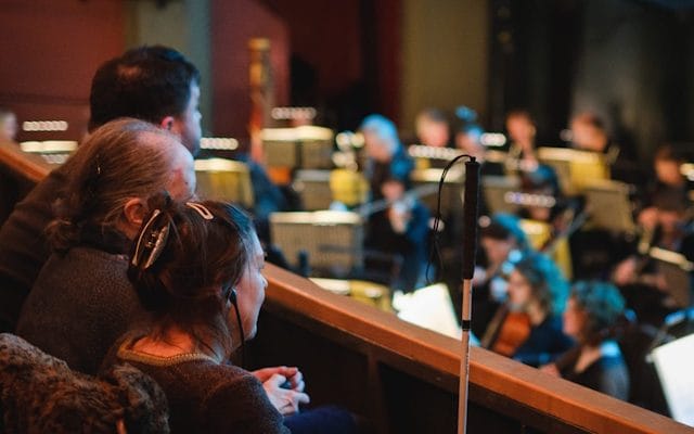 La imagen muestra a una persona disfrutando de una función distendida de una ópera. La fotografía fue tomada de la página web www.operanorth.co.uk